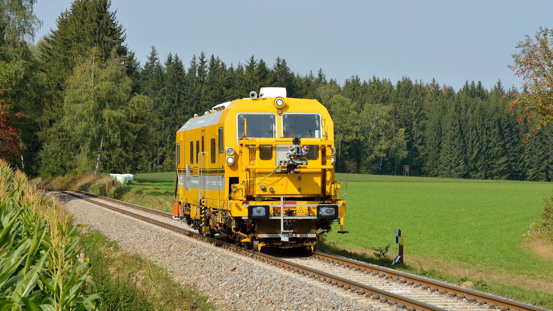 Multisensorplattform auf der Schiene mit grüner Wiese und Bäumen rundherum