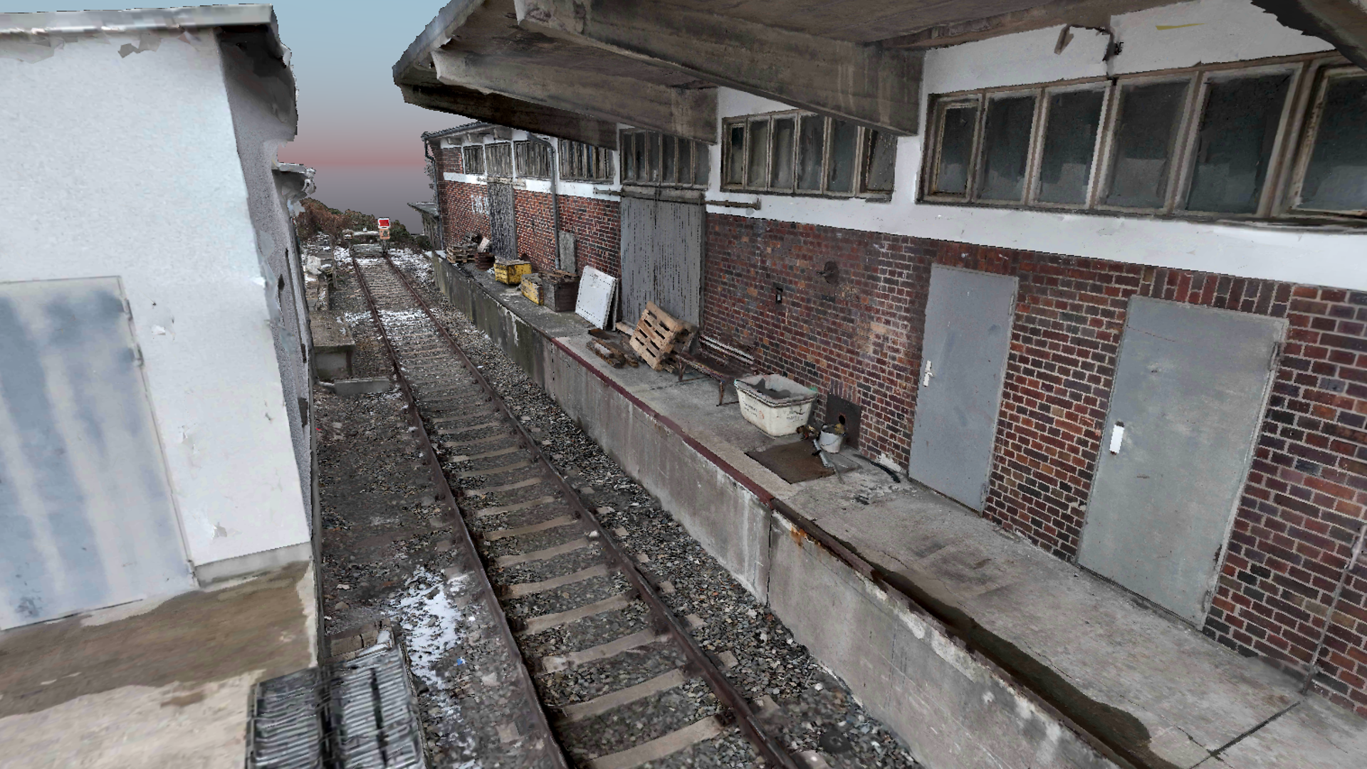 Close-up of a 3D point cloud of a brick building next to a track