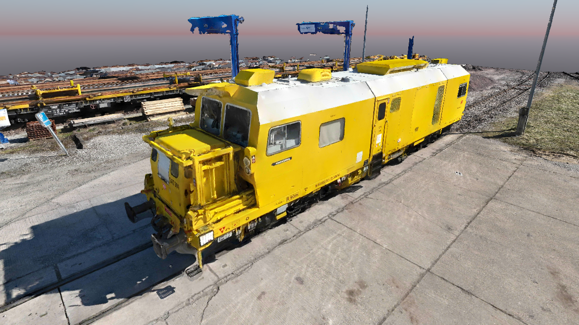 3D image of a yellow work vehicle on a railroad site