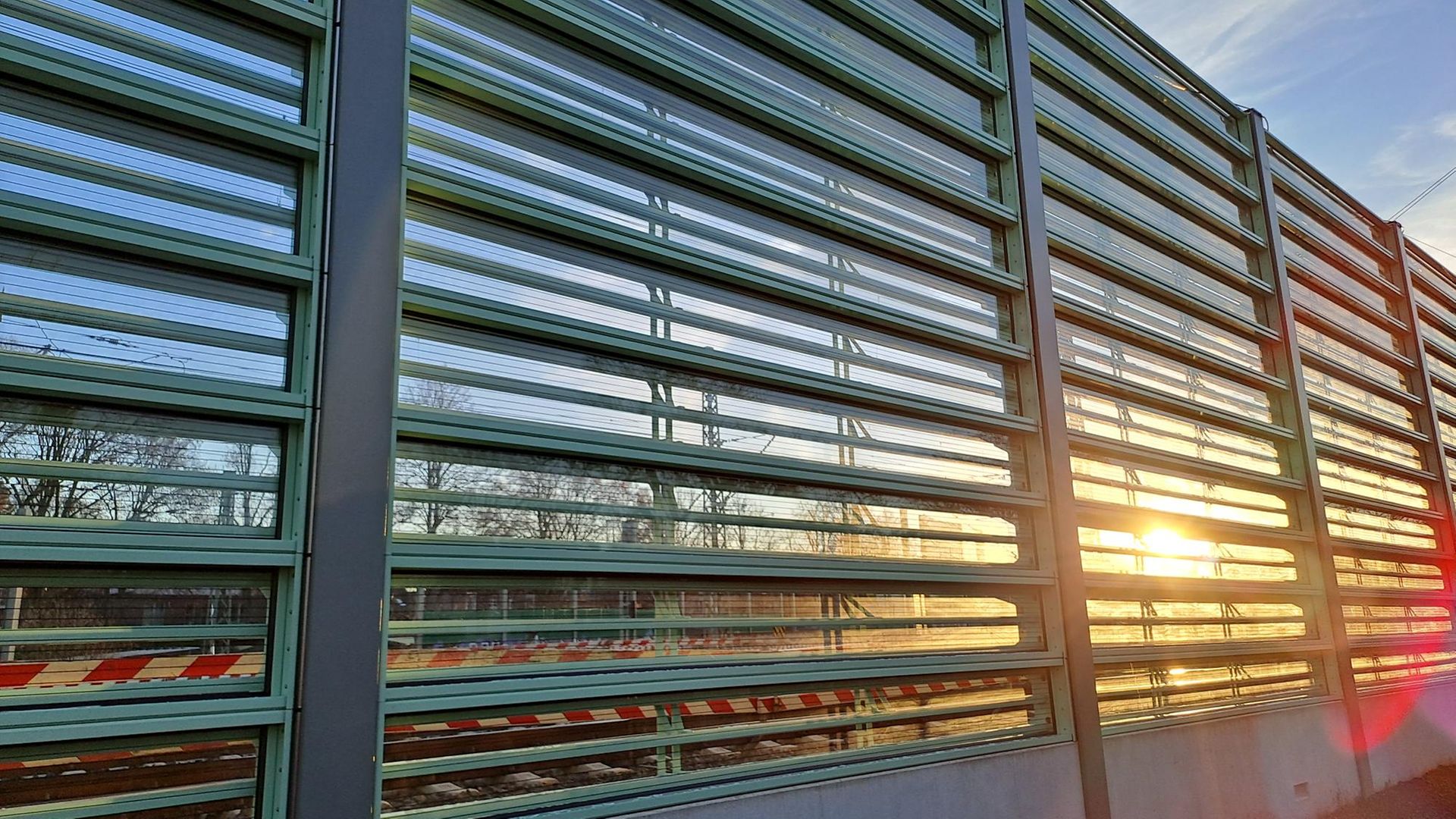 MetaWindow noise barrier on the Hamburg railway line at sunset