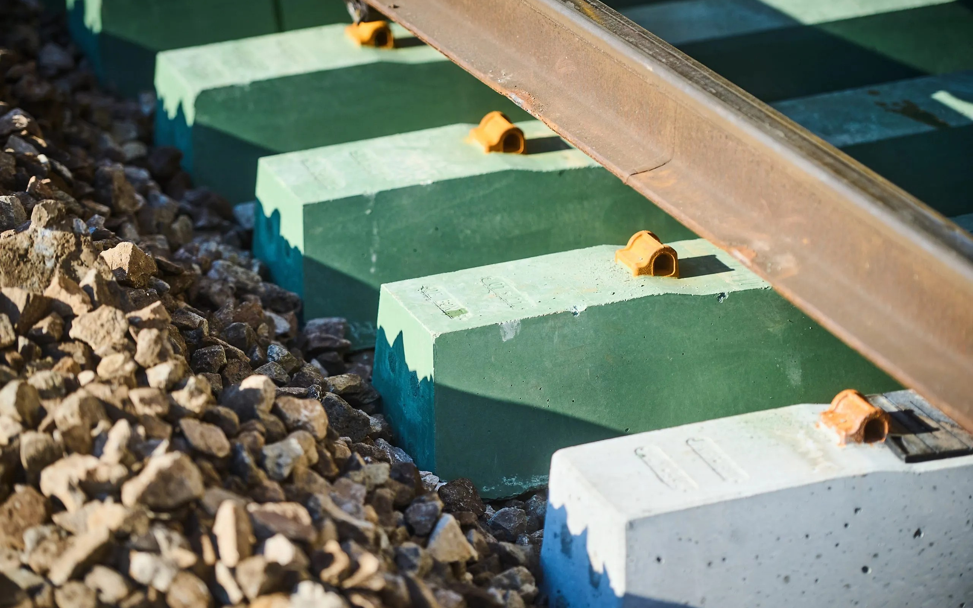 Close-up of the track bed with ballast and a sulphur concrete sleeper