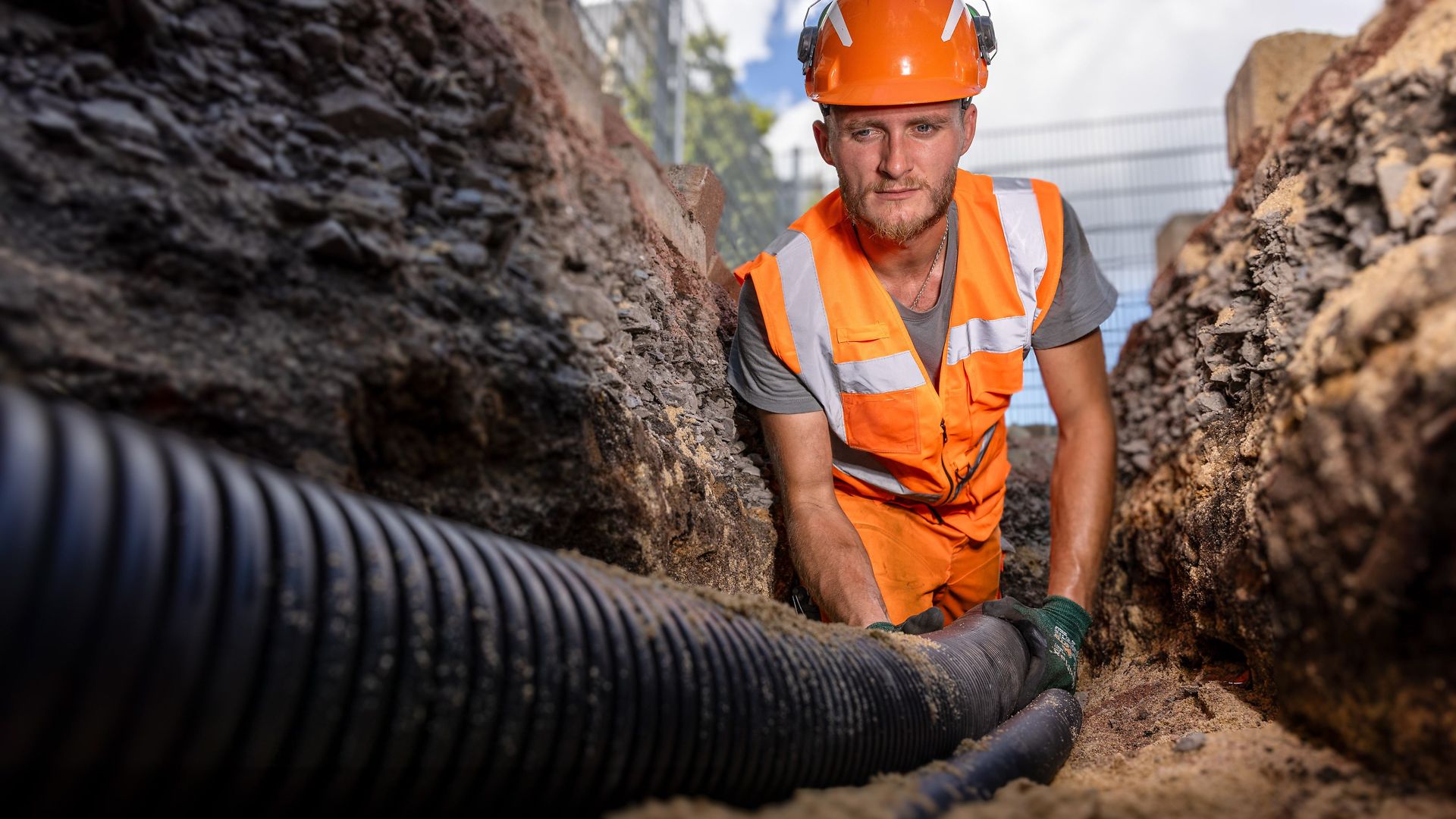 A member of staff is laying cable in a trench
