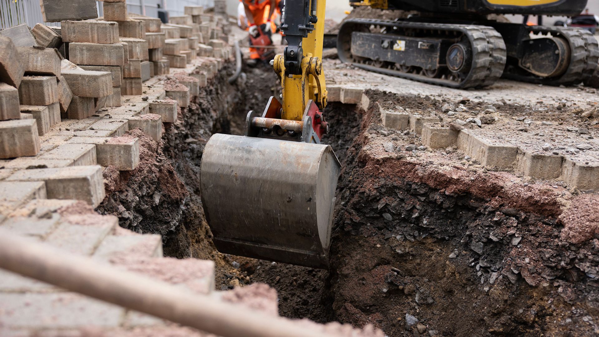 An excavator is digging out earth to make way for the underground cable installation