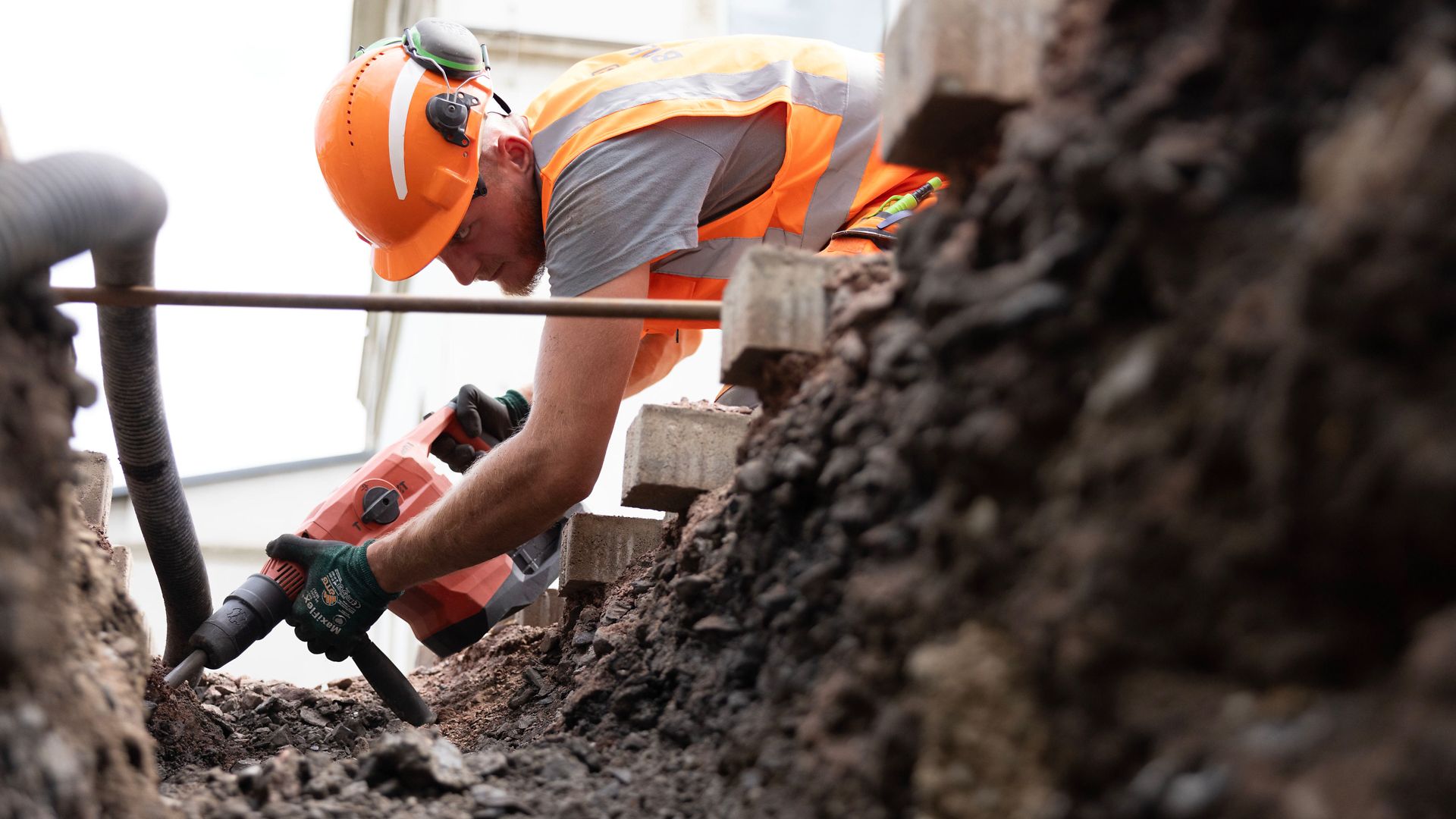 Employee digs a trench for underground cabling