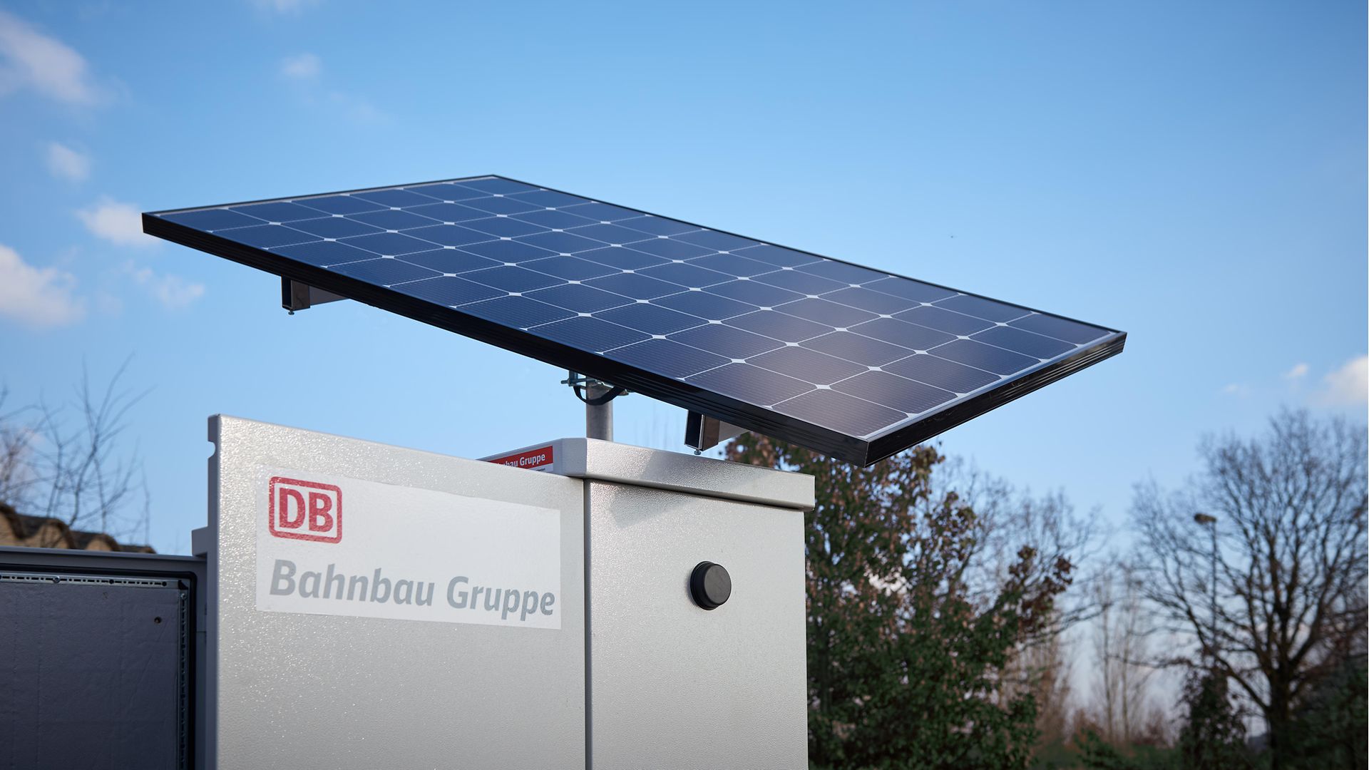 Schrank mit Photovoltaikzelle auf dem Dach und DB Bahnbau Gruppe Schriftzug am Schrank