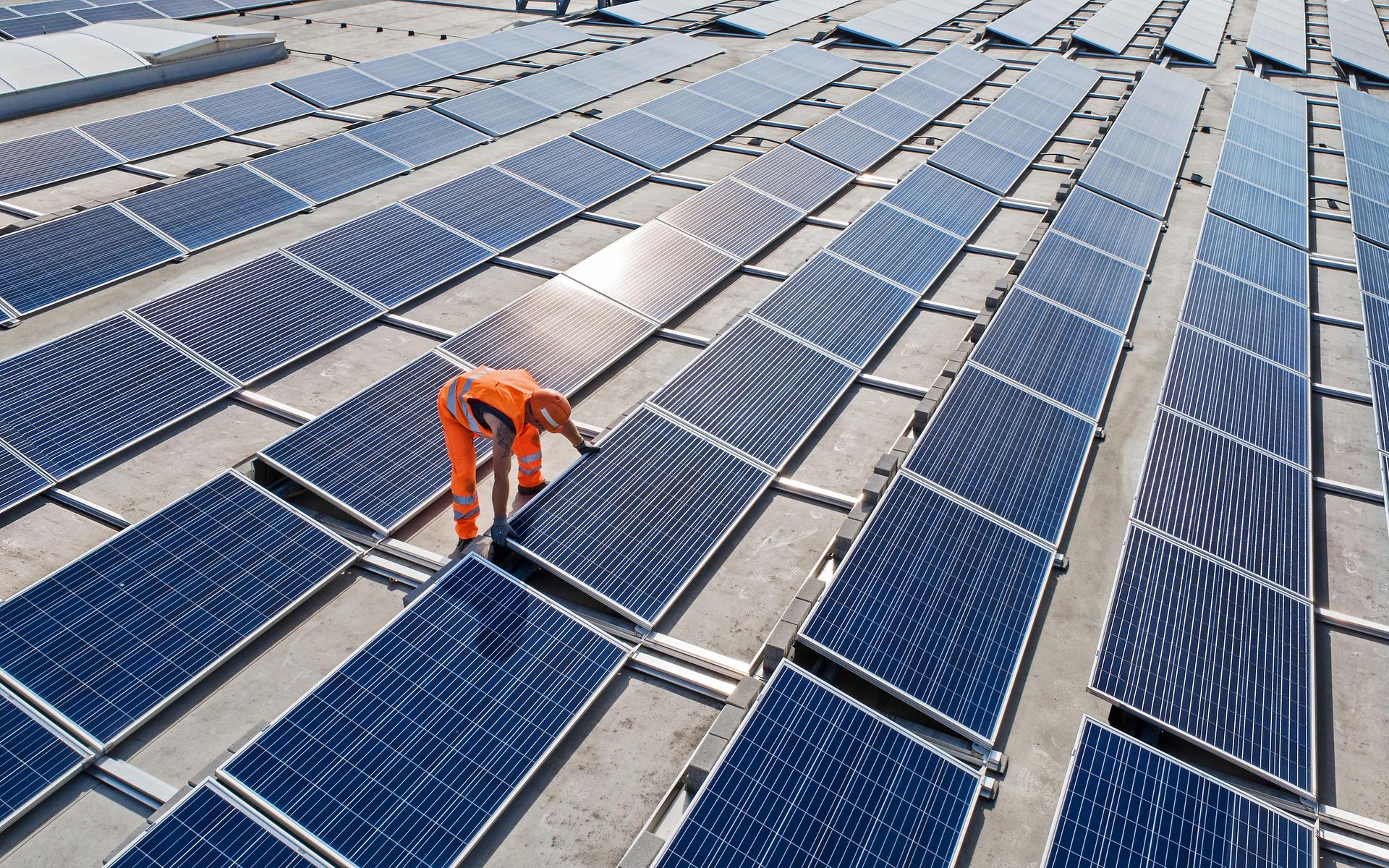 Mitarbeiter installiert Solarpanel auf einem Dach