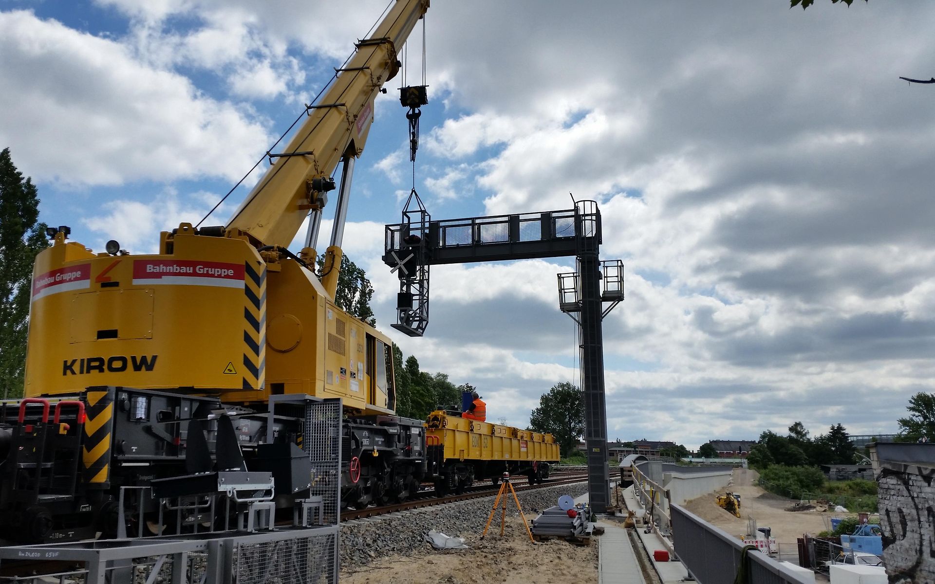 Signalausleger wird von gelbem DB Bahnbau Gruppe Kran angebracht