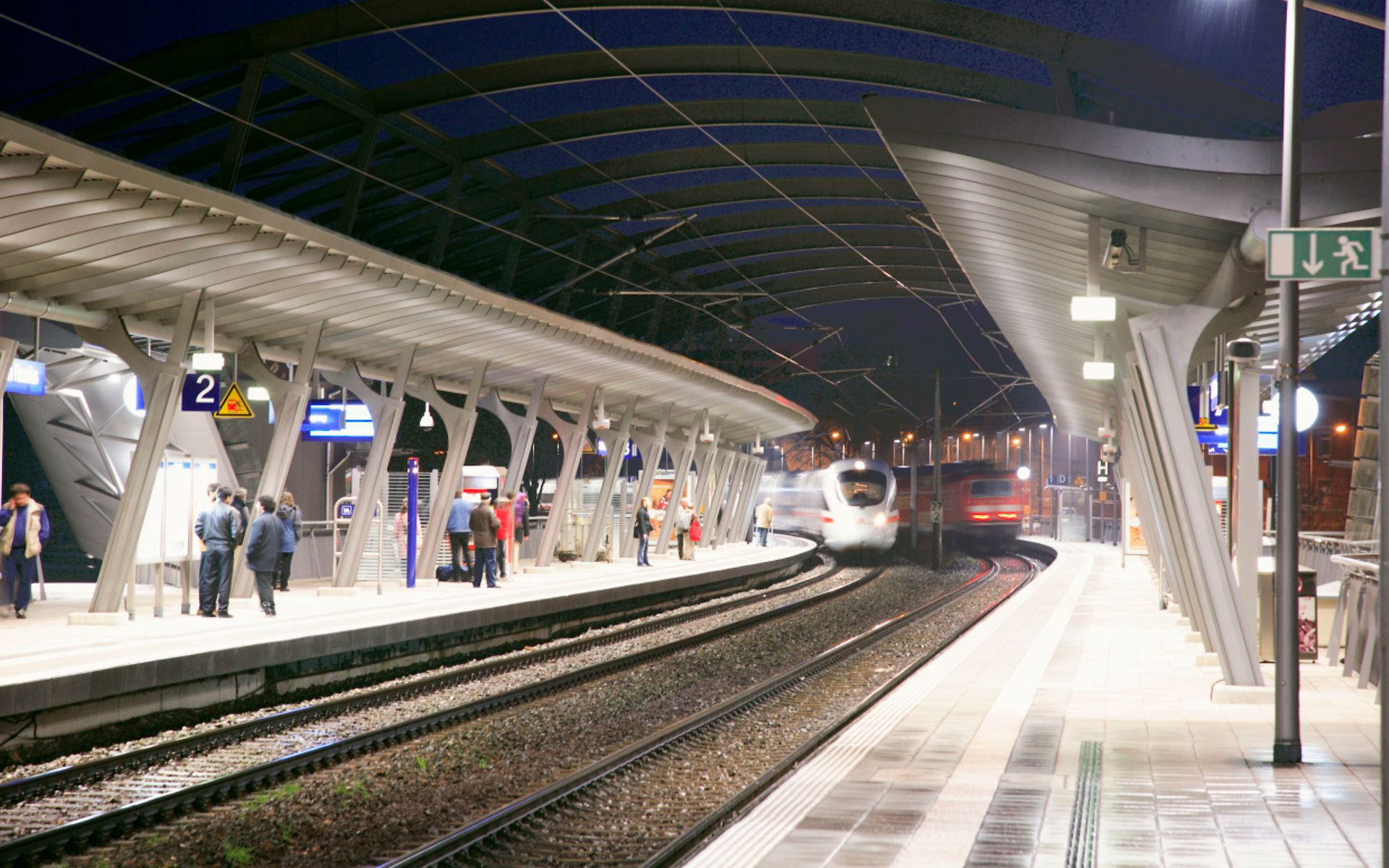 moderner Bahnsteig mit einfahrenden ICE bei Nacht