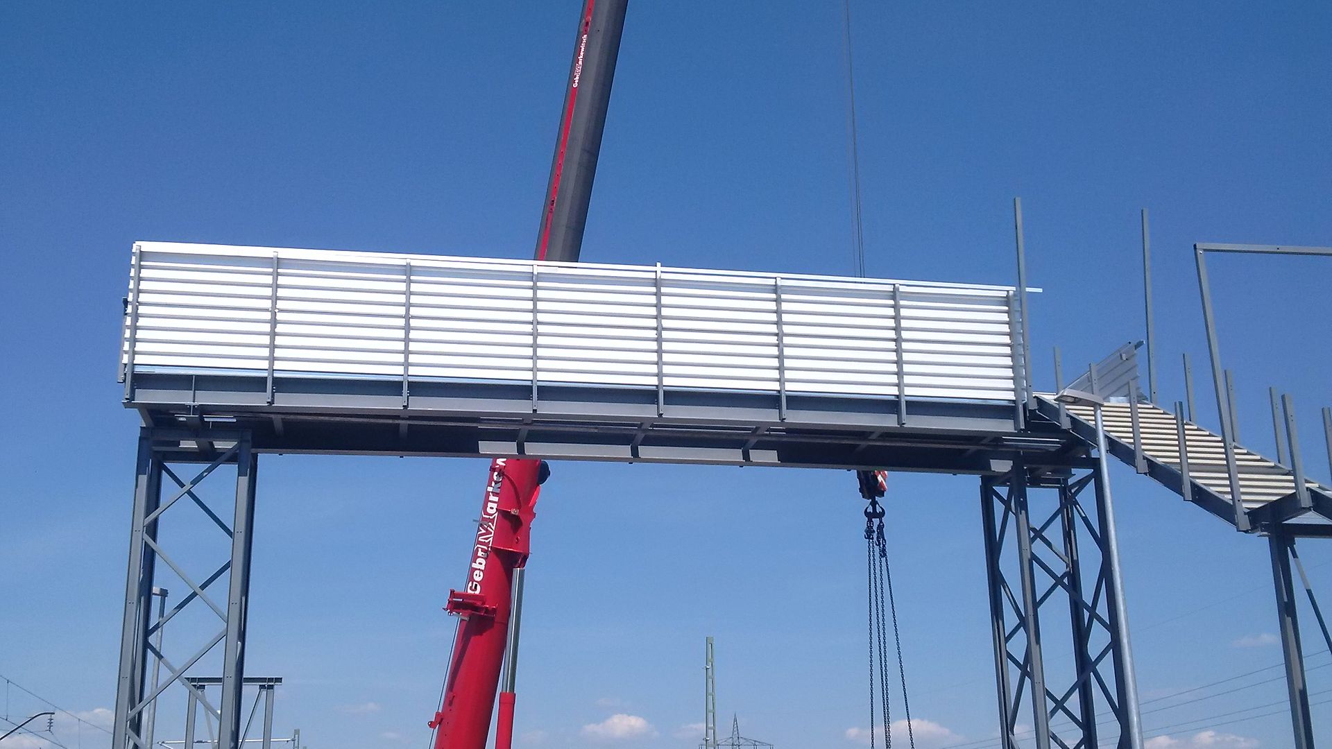 Kran hebt eine Fußgängerbehelfsbrücke ein