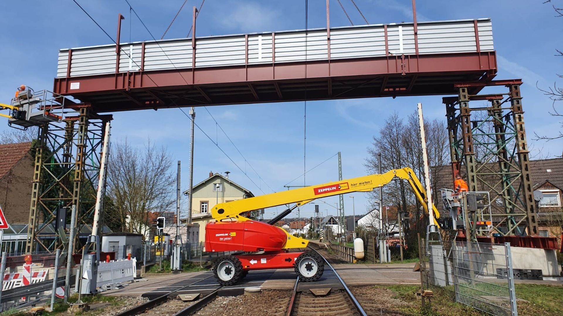 Bau einer Fußgängerbehelfsbrücke. Gelbe Maschine steht darunter.