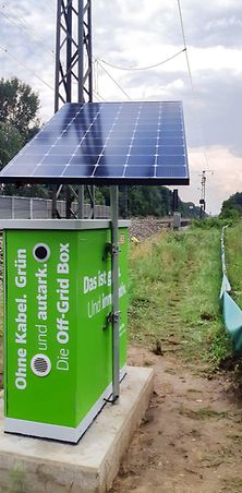 grüne Box mit Photovoltaikanlage als Energieversorgung an Strecke.