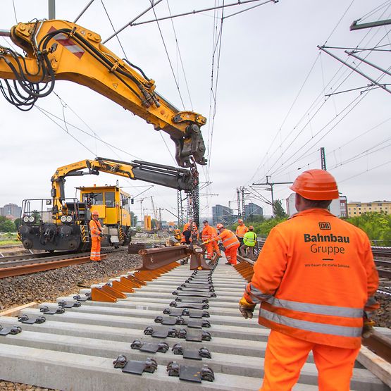 Baustelle Mitarbeiter verlegen Gleise mit Maschinen