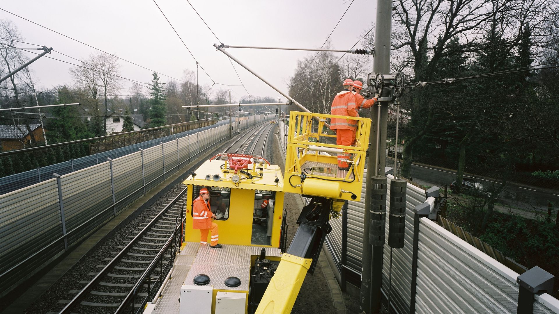 gelbe Maschine mit Kran zur Arbeit an Oberleitungen