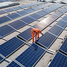Source: DB Bahnbau Gruppe/Max Lautenschläger viele Photovoltaikplatten mit Mitarbeiter, der diese montiert
