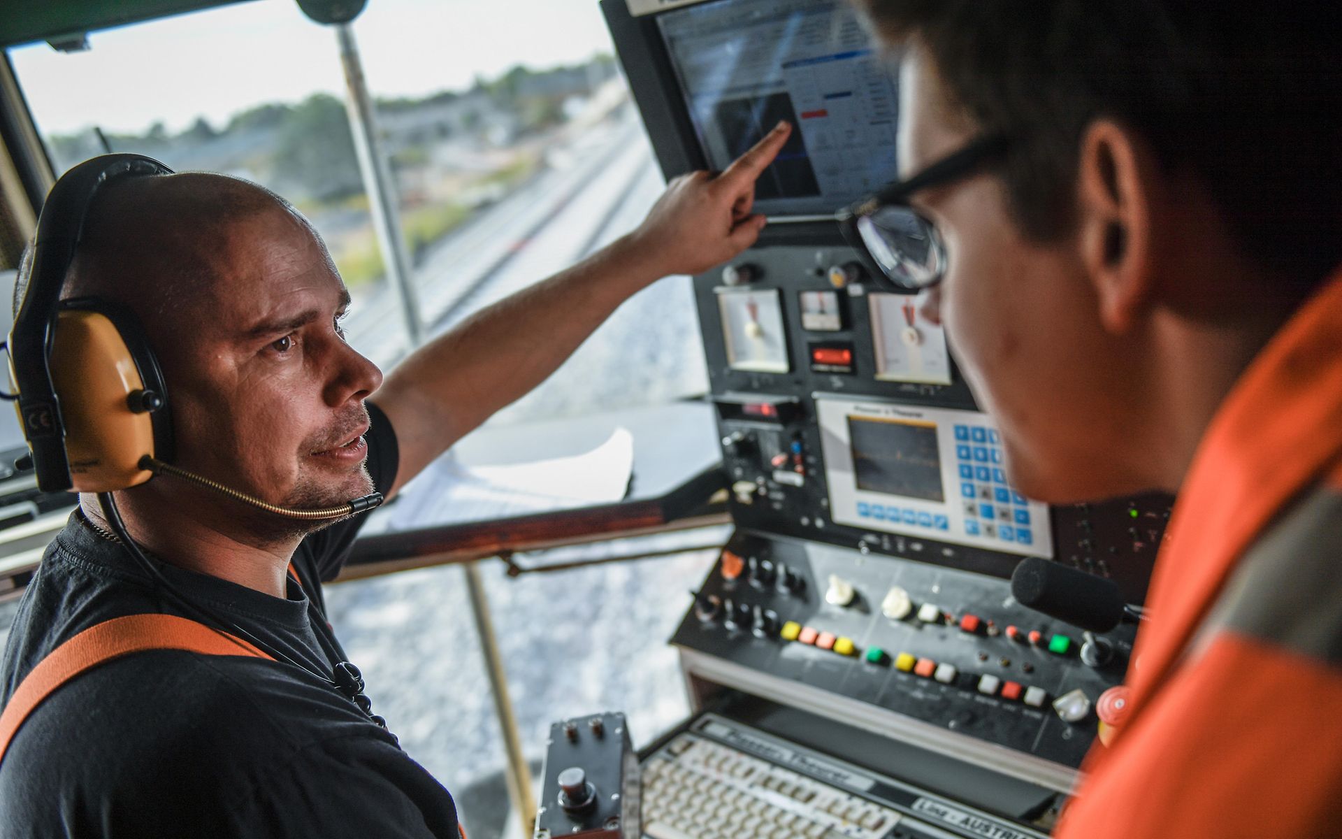 Mitarbeiter in Kabine von Gleismaschine