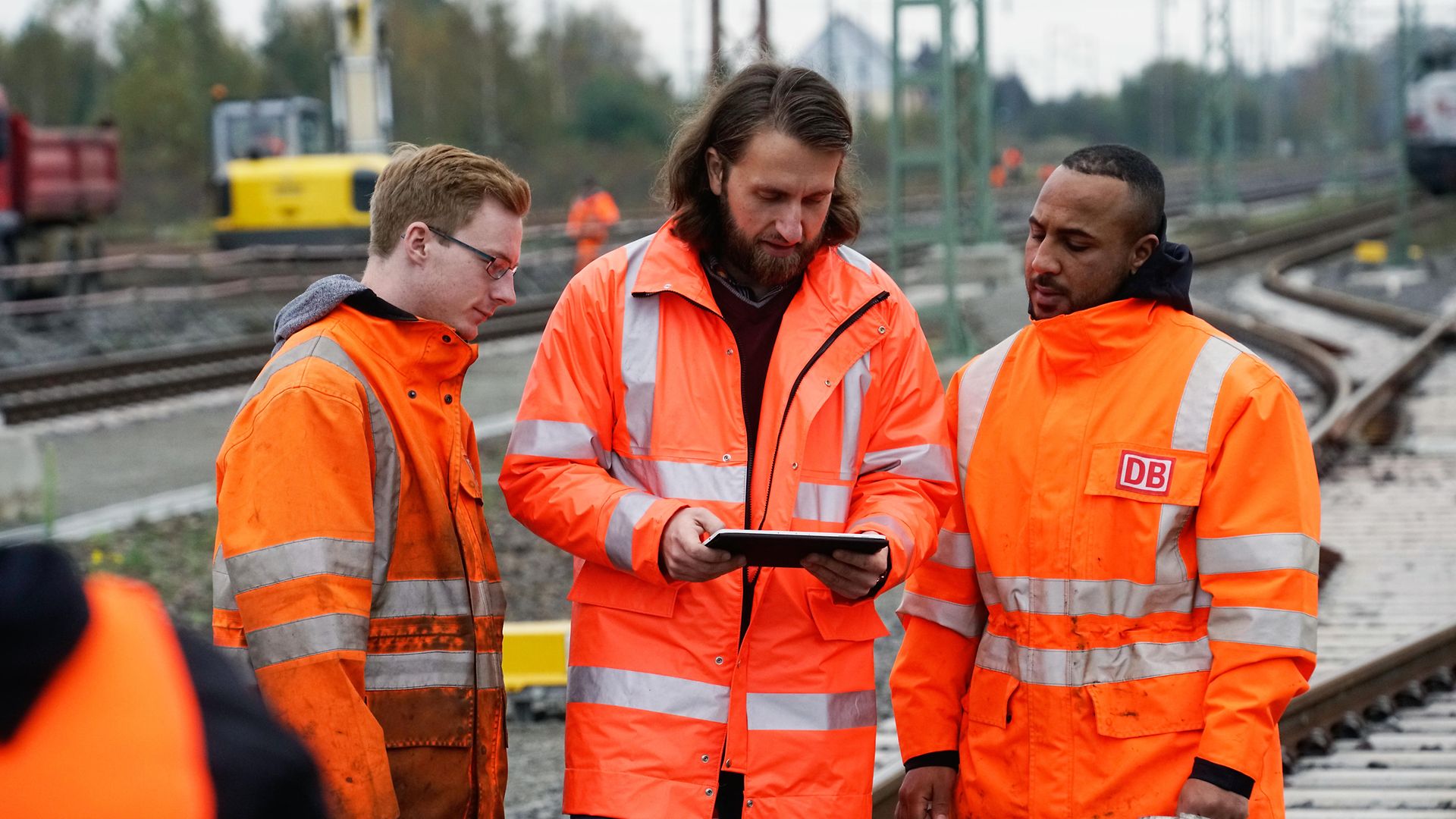 Mitarbeiter zeigt zwei anderen etwas auf dem Ipad