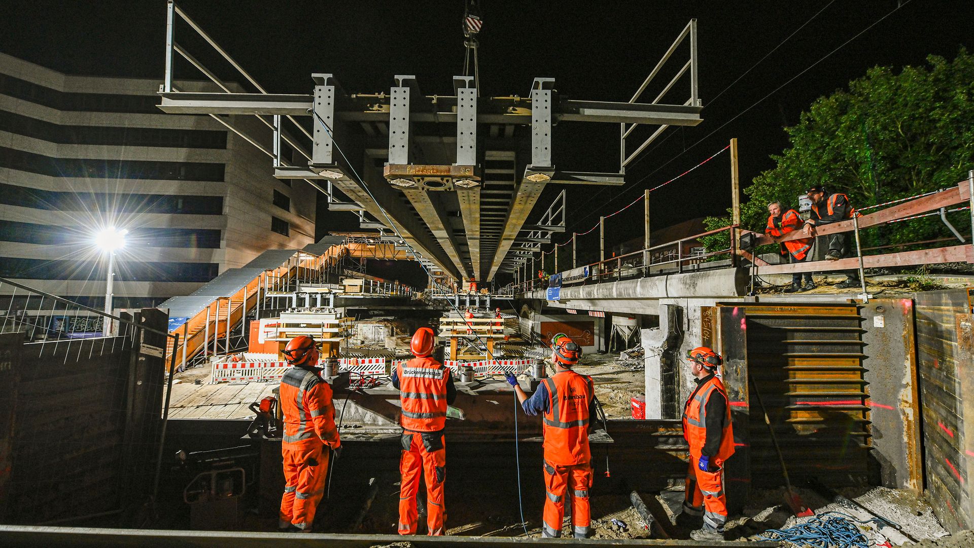 Absenken der Hilfsbrücke auf den Auflagerträgern bei Nacht