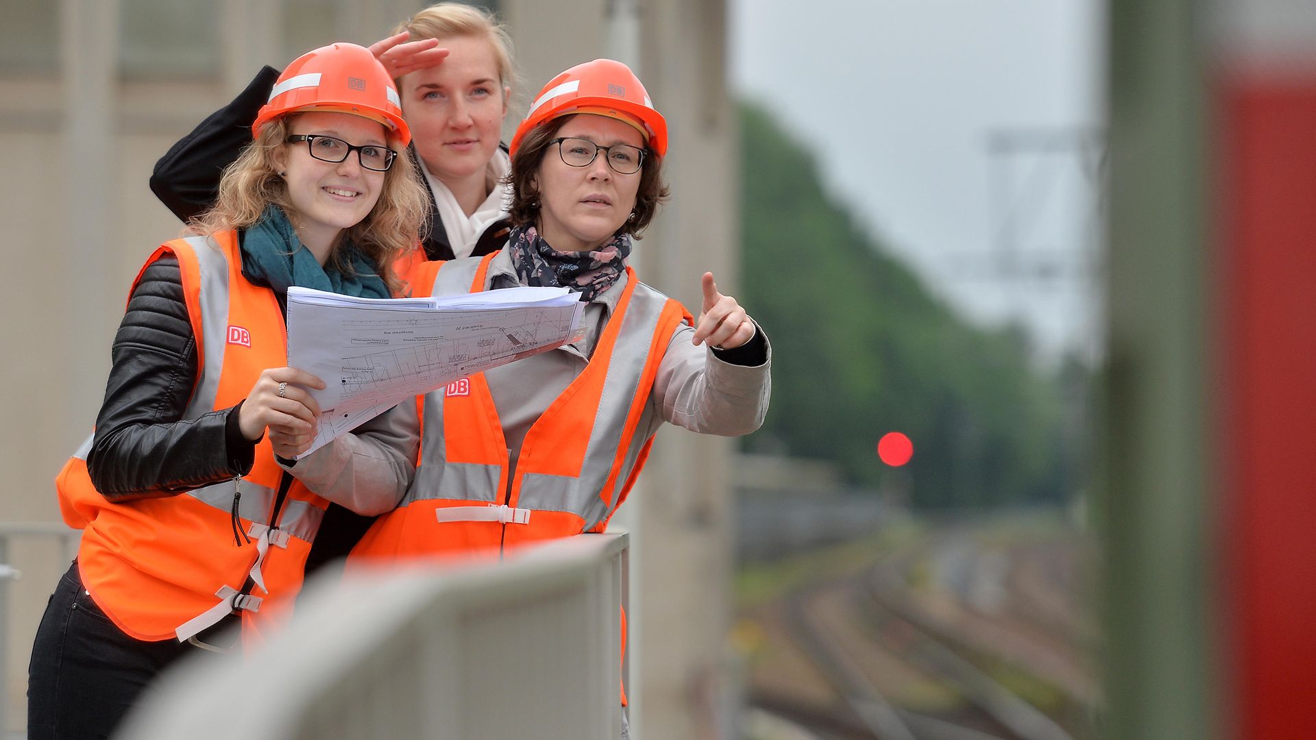 drei Frauen mit PSA und Bauplan auf der Baustelle