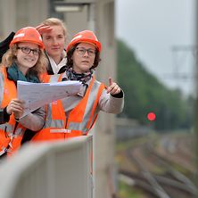 drei Frauen mit PSA und Bauplan auf der Baustelle