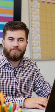 Mann sitzt im Büro vor dem Laptop